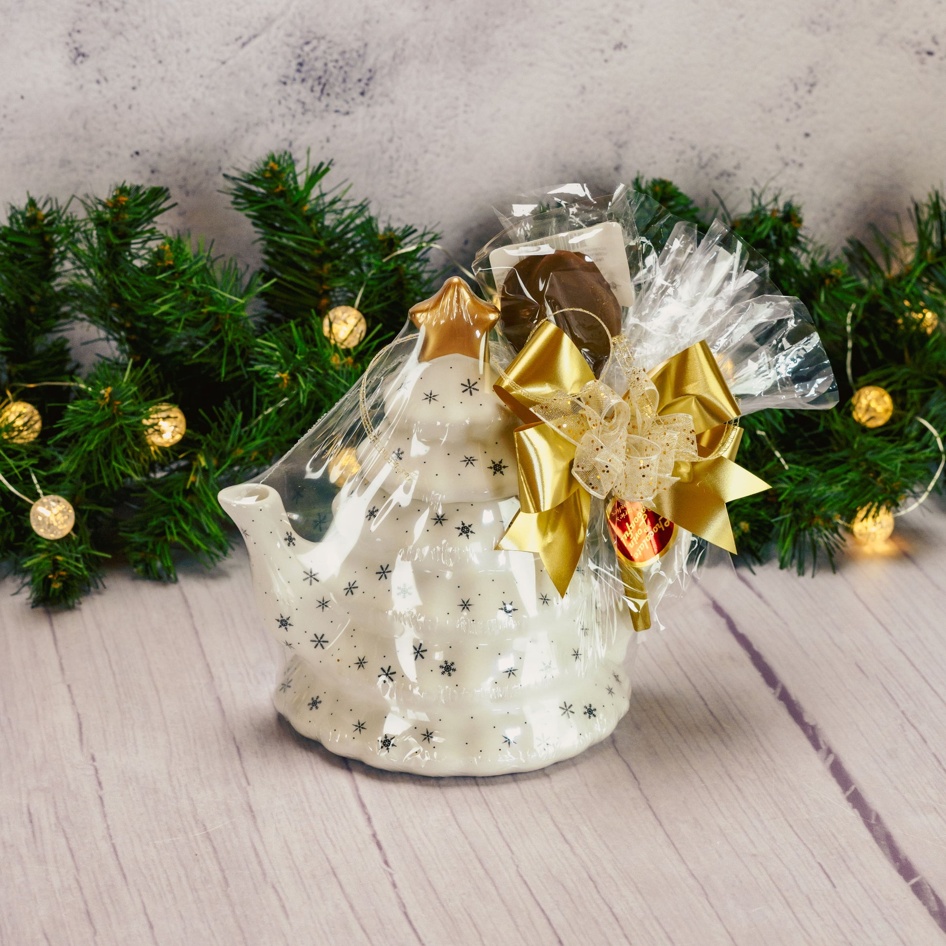 a white tree shaped teapot packaged with sweet treats