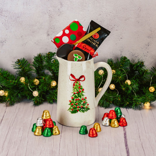 a tall pitcher with a hand painted tree on it is filled with sweet treats