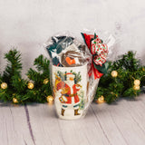 a Santa & reindeer mug is filled with sweet treats. Mug has a stencil for cappuccino and other drinks