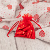 six milk chocolate foil wrapped hearts are placed in a red gauzy pouch.