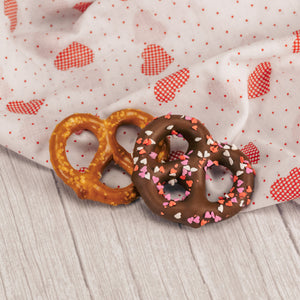 a jumbo pretzel covered in smooth milk chocolate with Valentine heart sprinkles. 