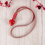 2 red foil milk chocolate hearts together on festive ribbon makes a lovely necklace to wear for the holiday! 