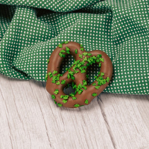 a jumbo pretzel covered in milk chocolate and sprinkled with clover sprinkles for St. Patrick's Day