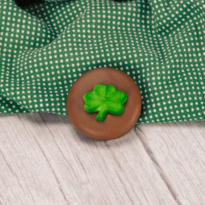an oreo cookie covered in milk chocolate with a sugar shamrock decoration on top