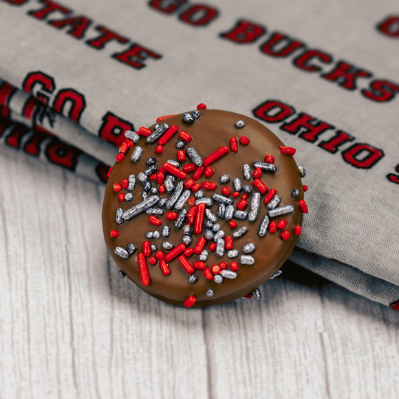 Milk chocolate covered Oreo with scarlet and gray sprinkles on top.