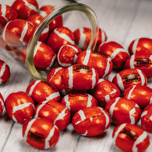 Football shaped milk chocolates wrapped in foil that looks like footballs.