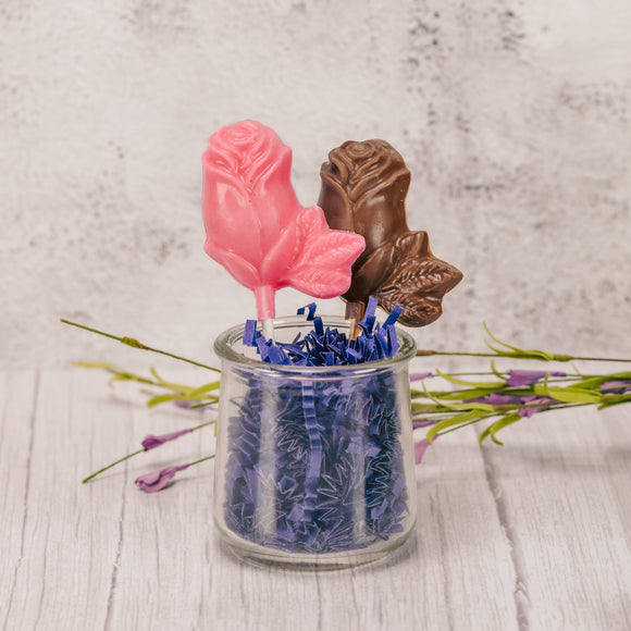 A flower rose on a sucker stick in milk chocolate or pink coating.