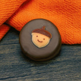 Oreo cookie dipped in milk chocolate with fall acorn face decoration on top.