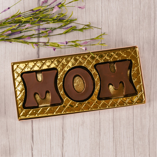 Milk chocolate letters M, O, M are placed in a box with a clear lid and ready to be presented to the best mom for mother's day! 