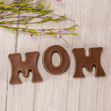 Milk chocolate letters M, O, M are placed in a box with a clear lid and ready to be presented to the best mom for mother's day! We can gift wrap the box.