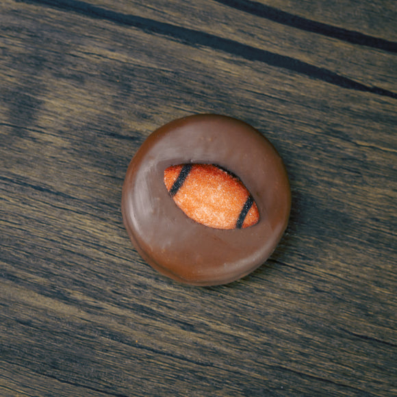 Milk chocolate covered oreo cookie with a sugar football decoration on top