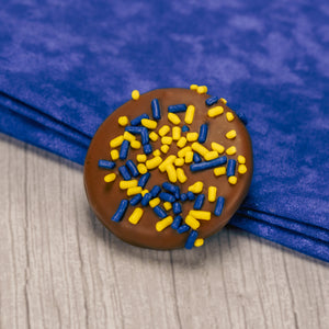 Oreo cookie covered in smooth milk chocolate and sprinkled with maize and blue sprnkles.