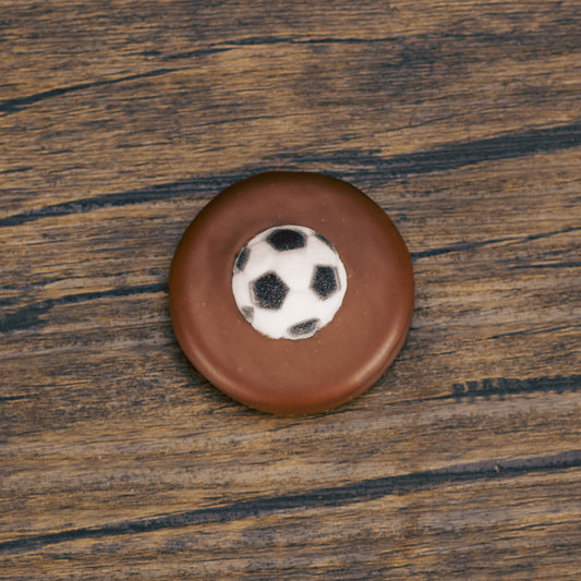 an Oreo cookie covered in milk chocolate with a soccer ball sugar decoration