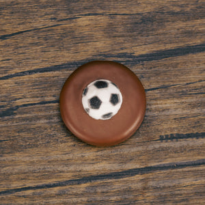 an Oreo cookie covered in milk chocolate with a soccer ball sugar decoration 