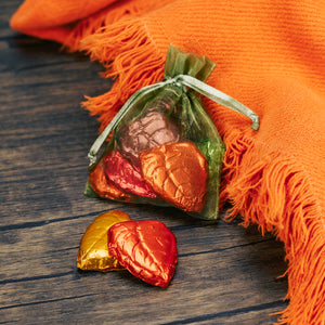 six foil wrapped milk chocolate leaves in a gauzy pouch.