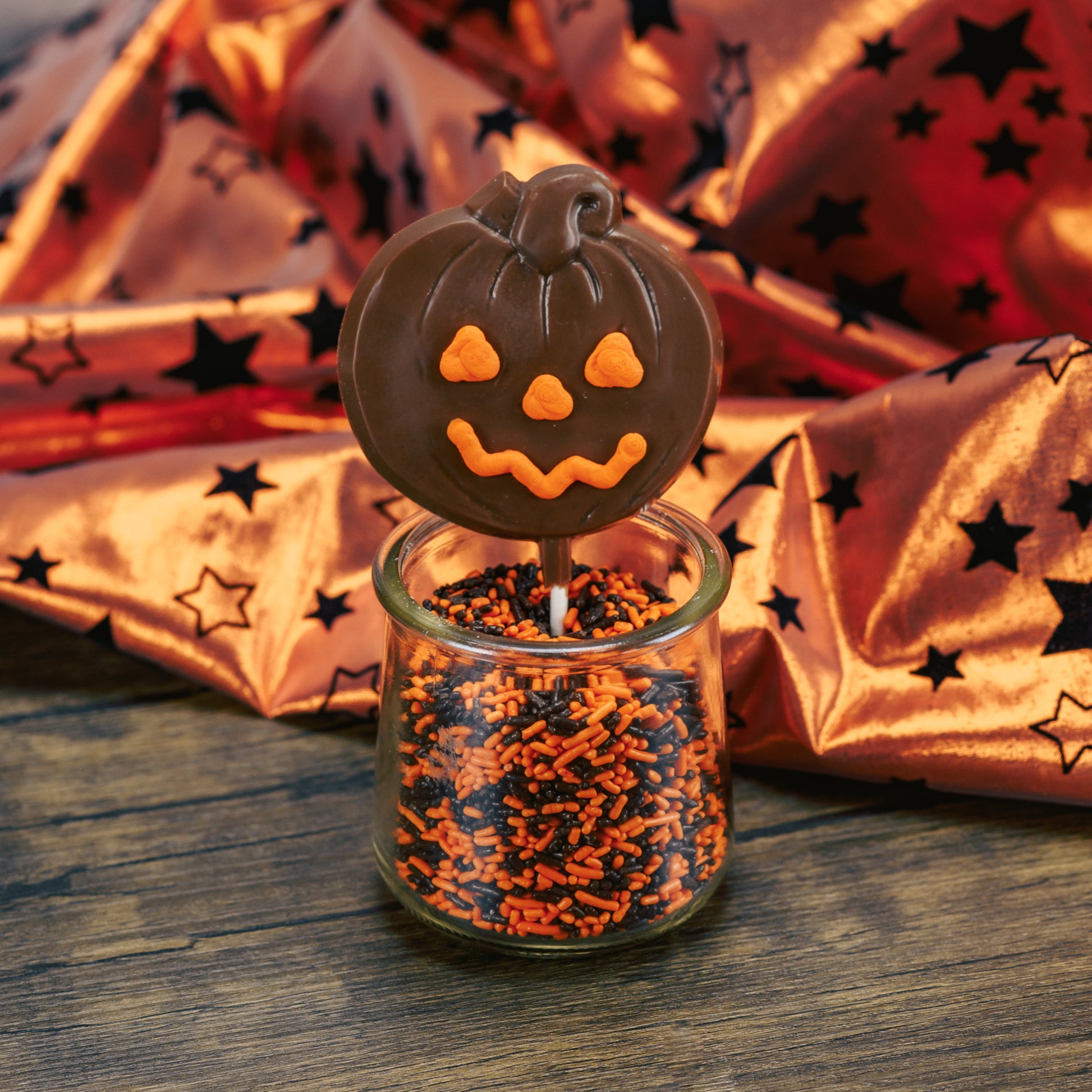 Milk chocolate pumpkin on a sucker stick. With orange icing for eyes, nose and smile.