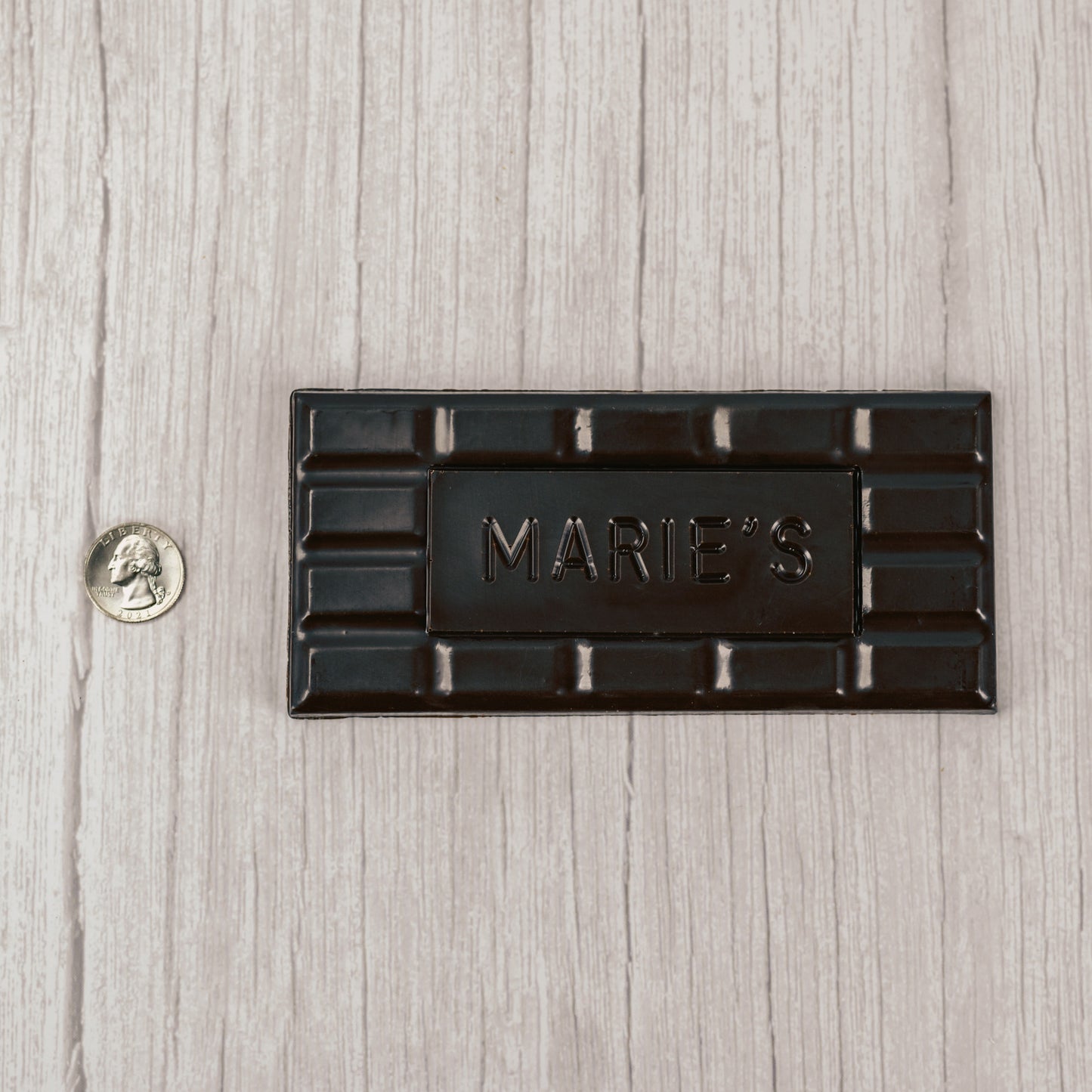  dark chocolate molded into a bar that says "Marie's"