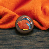 An Oreo cookie covered in milk or dark chocolate with a Thanksgiving turkey or cornucopia sugar decoration on top.