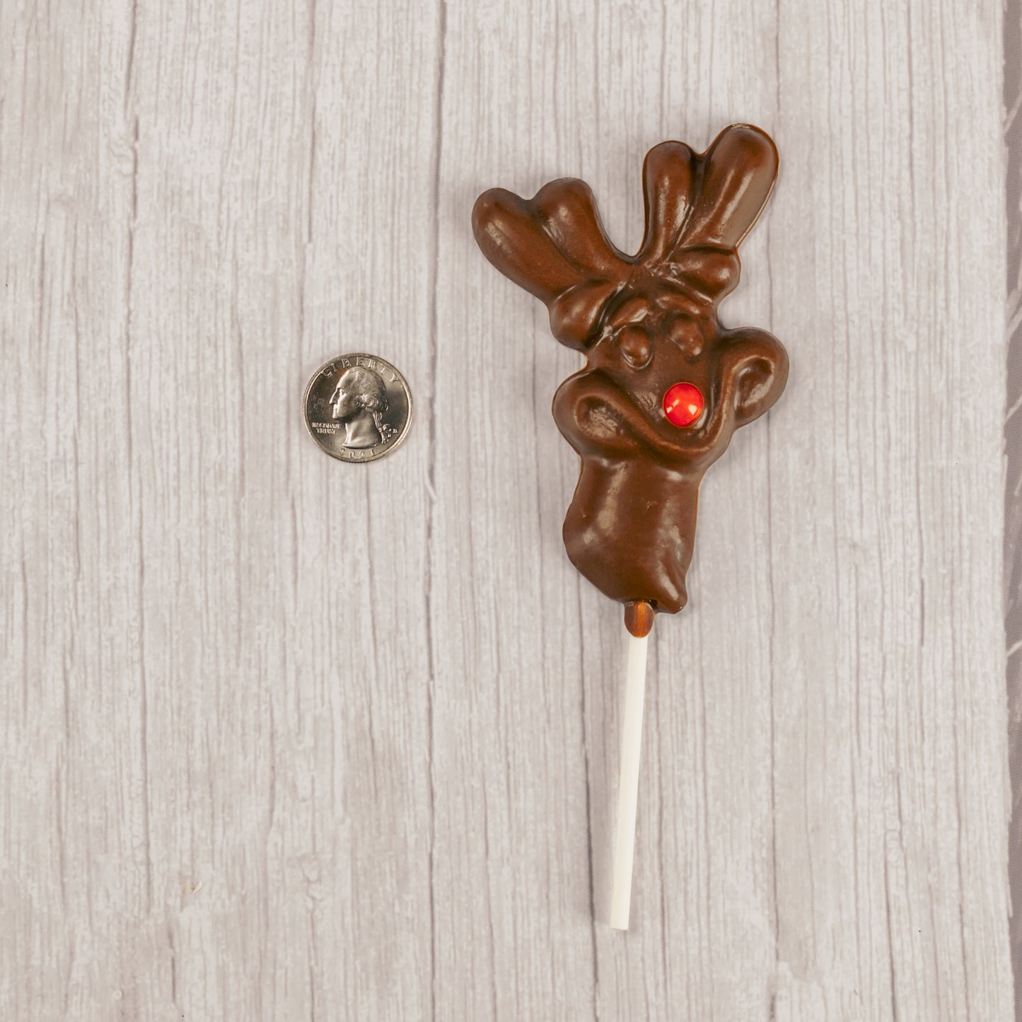Milk chocolate Rudolph reindeer on a sucker stick. Red sixlet as its' nose