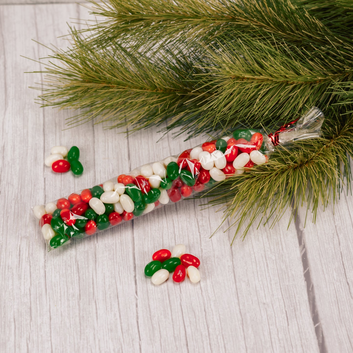 Red, green and white jelly belly beans in a long clear sleeve. Red apple, green apple, coconut and cherry flavors.