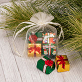 a small gauzy pouch filled with four milk chocolate presents. Assorted colors of pouches; red, green and white.