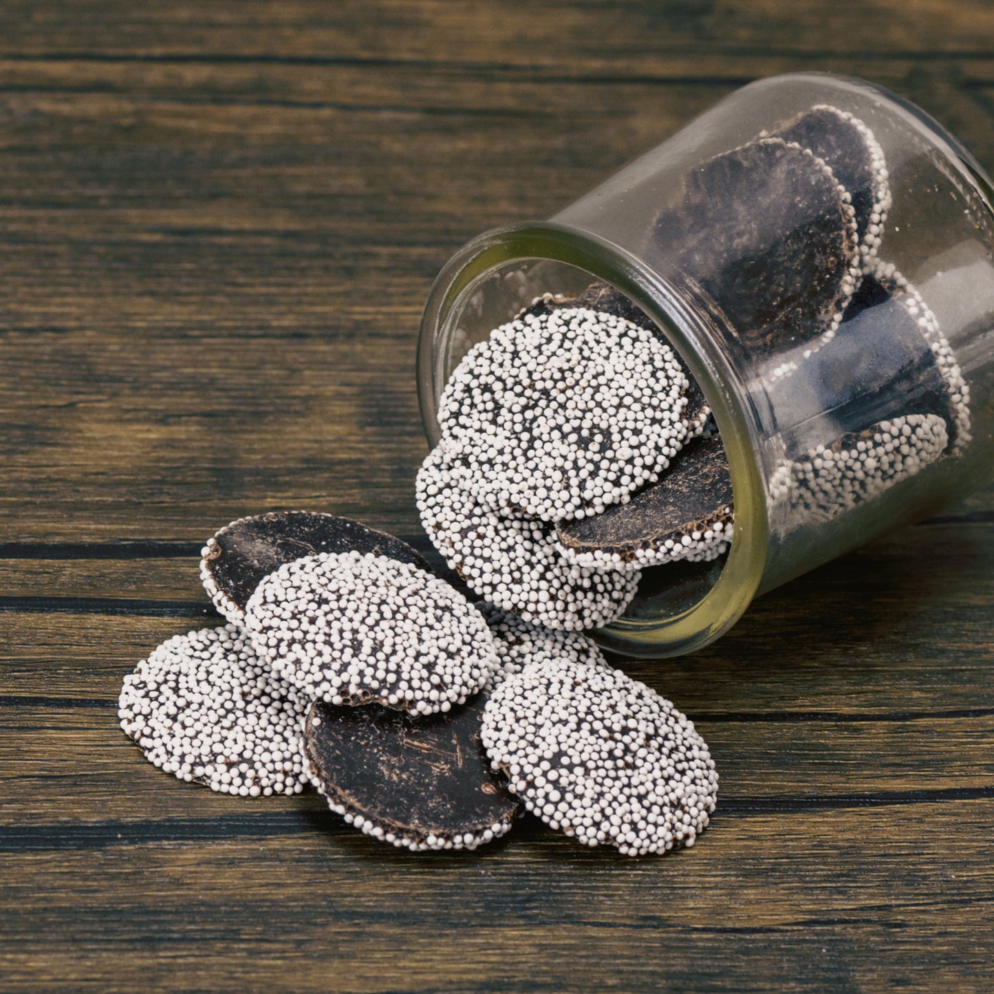 Flat dark chocolate with white nonpareils in half pound bags.