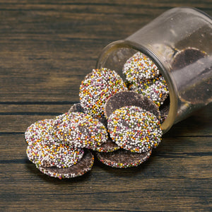 Flat milk chocolate wafers covered in rainbow nonpareils or dark chocolate with white nonpareils in half pound bags.