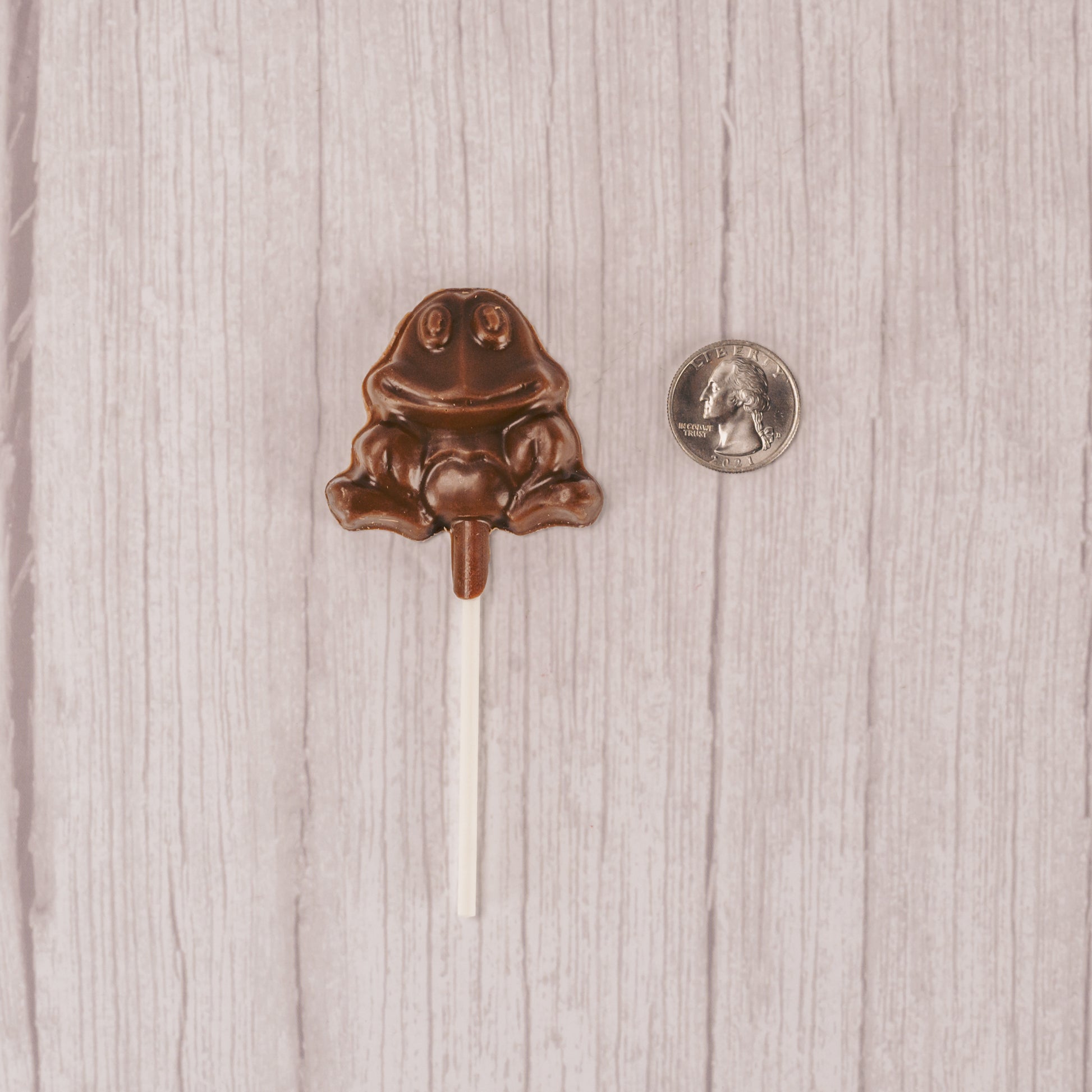 small frog on a stick in milk chocolate, placed in a cello bag and tied.