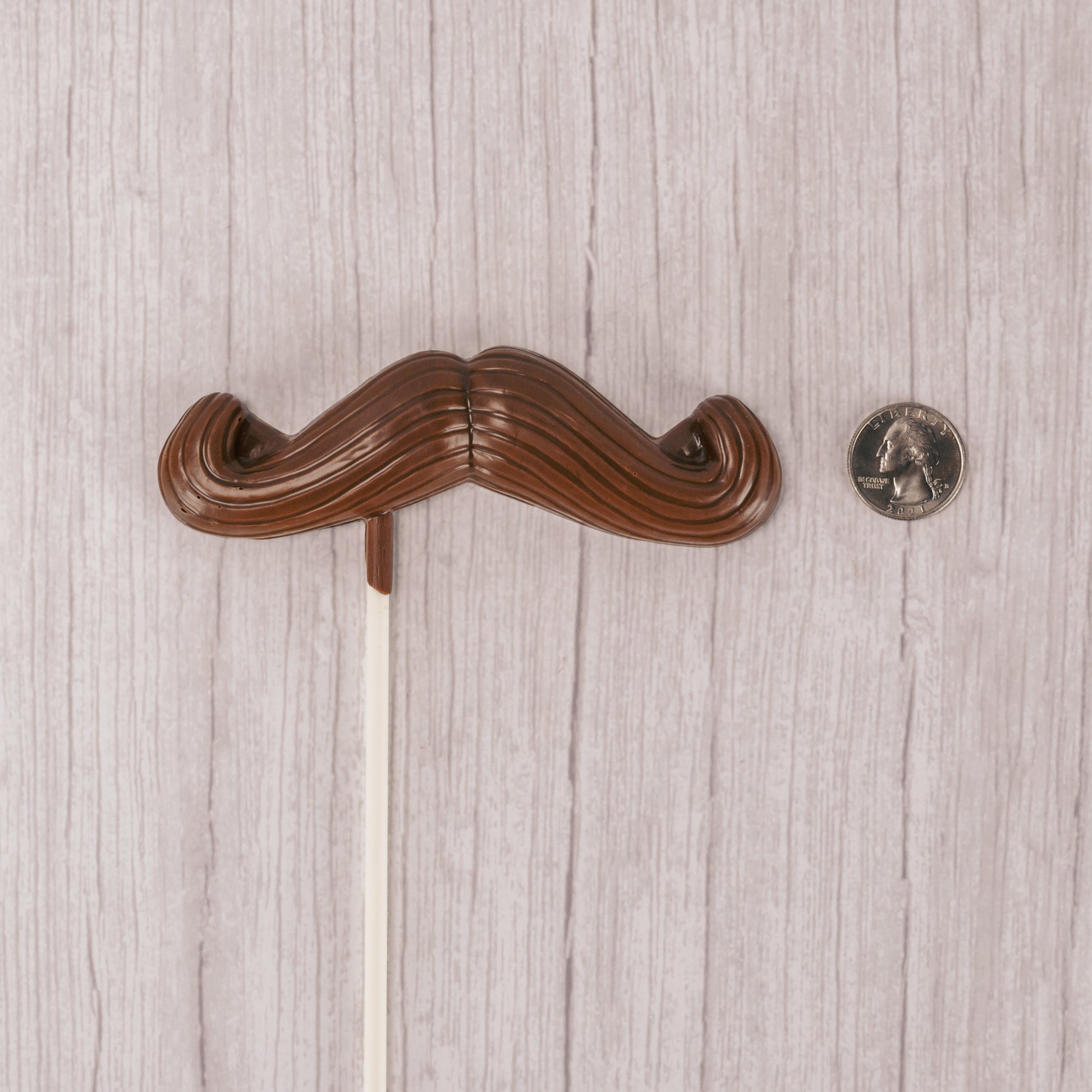 Milk chocolate mustache on a large sucker stick.