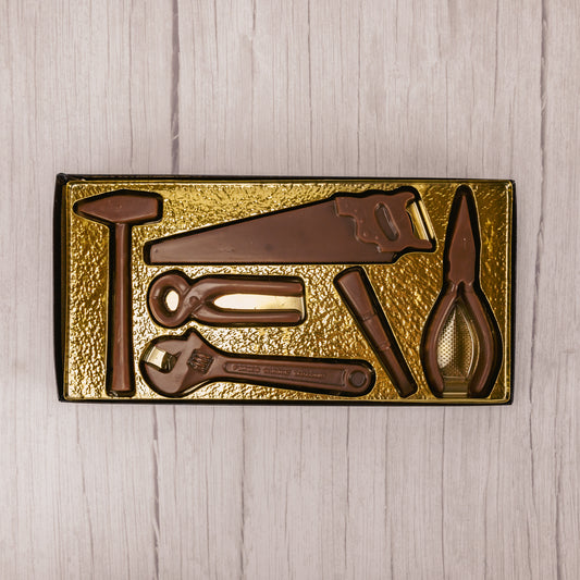 A collection of tools that are made out of milk chocolate and assembled in a box altogether.