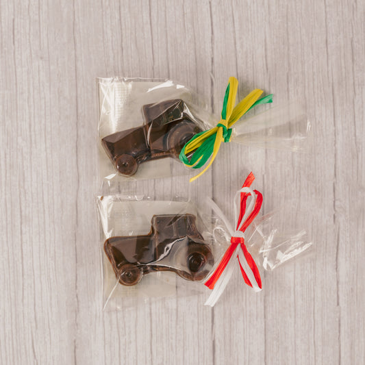 a small milk chocolate tractor. Individually packaged and tied with green and yellow ribbon or red and white ribbon.