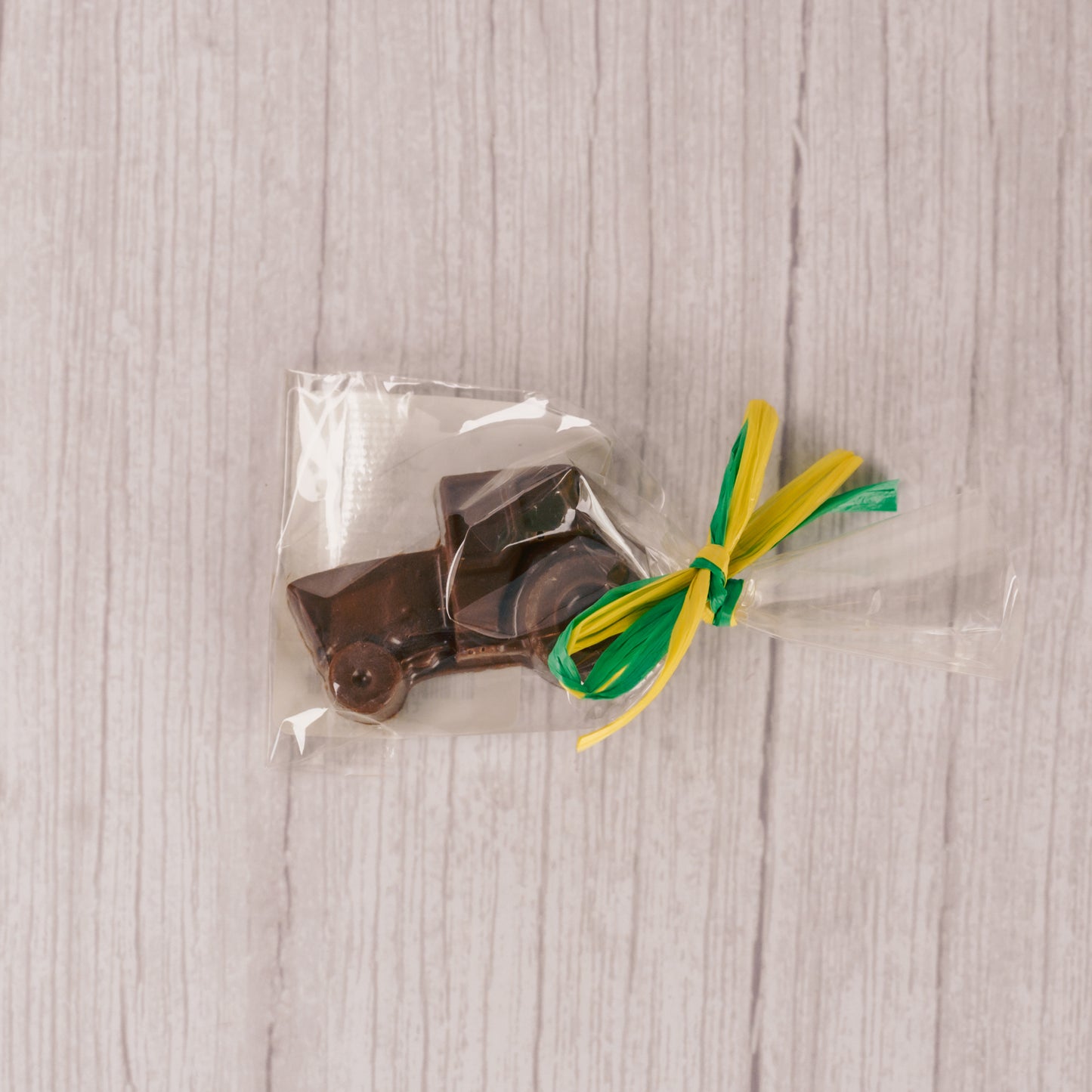 a small milk chocolate tractor. Individually packaged and tied with green and yellow ribbon ribbon.