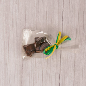 a small milk chocolate tractor. Individually packaged and tied with green and yellow ribbon or red and white ribbon.