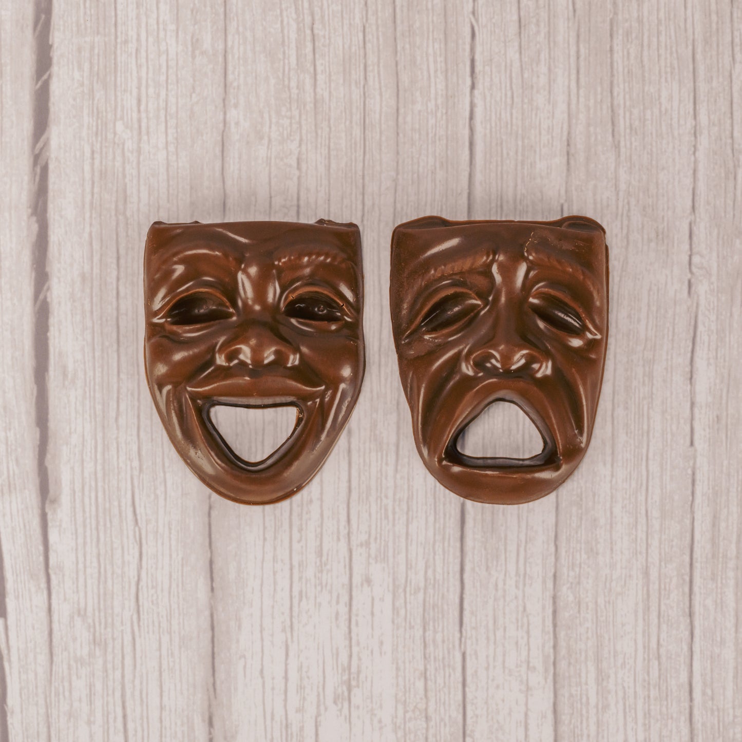 a drama mask smiling or frowning in milk chocolate.
