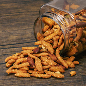 a pound bag of party mix that includes roasted and salted almonds, cashews, peanuts, sunflower seeds, pepitas, cheddar sesame sticks, garlic sesame sticks, and poppy onion sesame sticks.