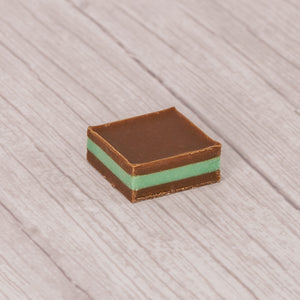 Silky milk chocolate with green mint layered and packaged in a half pound clear rectangle tubes.