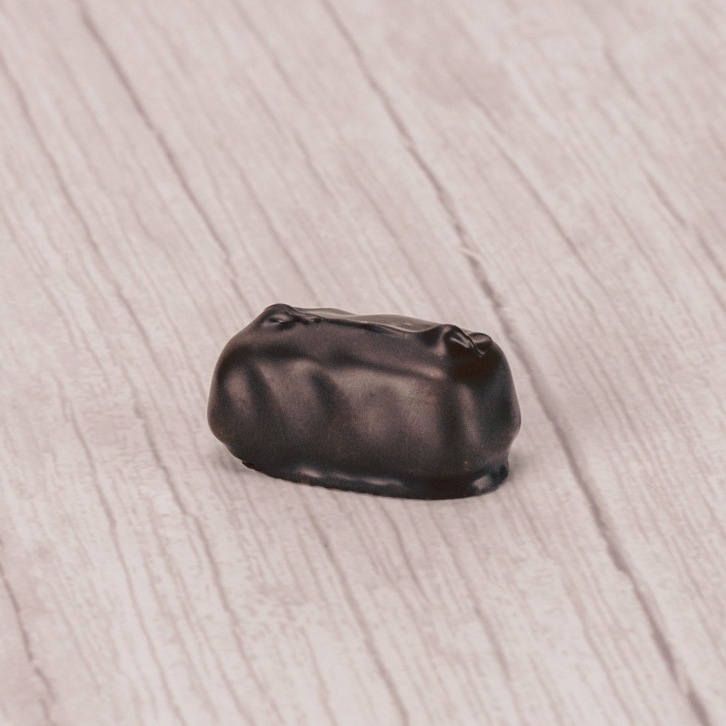 Raspberry jelly center dipped in dark chocolate in a pound box.