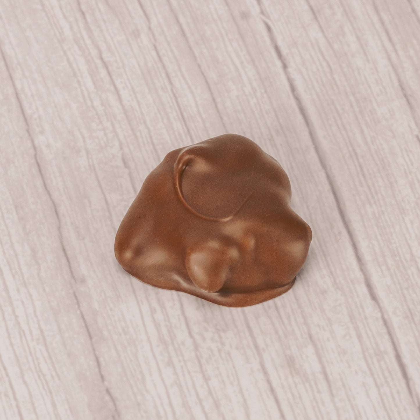 crunchy cashews with caramel covered in milk chocolate in a pound box.