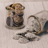 Flat milk chocolate wafers covered in rainbow nonpareils or dark chocolate with white nonpareils in half pound bags.