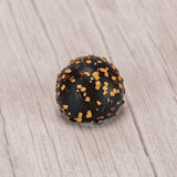 dark chocolate tiramisu truffle with brown and tan sprinkles on top