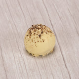 white cappuccino truffle with brown and white sprinkles on top