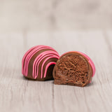 Marie's truffles made only five times a year that are made with cream and butter and have a mouse fluffy center. A box of 6 raspberry with pink icing drizzle.