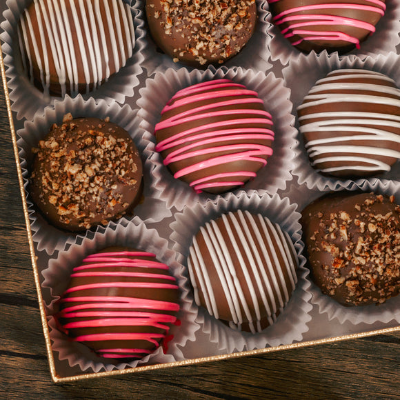 Marie's truffles made only five times a year that are made with cream and butter and have a mouse fluffy center.  A box of 12, choose between Chocolate with white drizzle icing, chocolate with crushed pecans or raspberry with pink icing drizzle