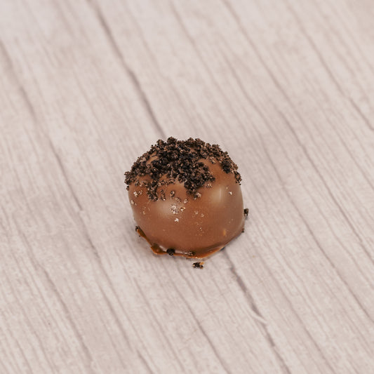 a rich vanilla cream mixed with crushed oreo cookies and covered with smooth milk chocolate with cookie crumb sprinkles on top.
