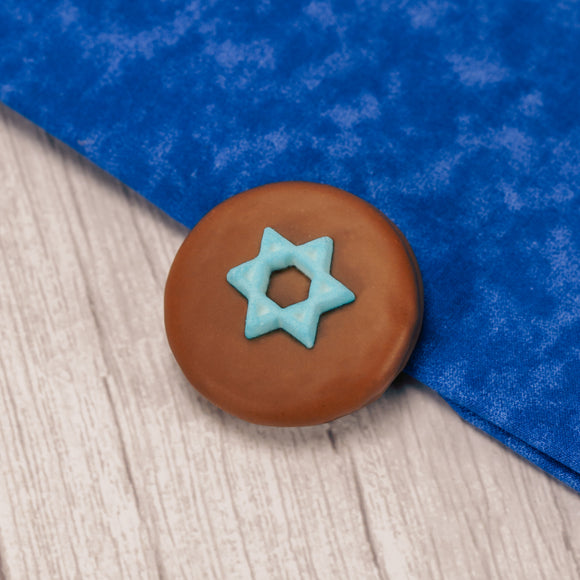 A milk chocolate cookie with a blue Star of David sugar decoration.