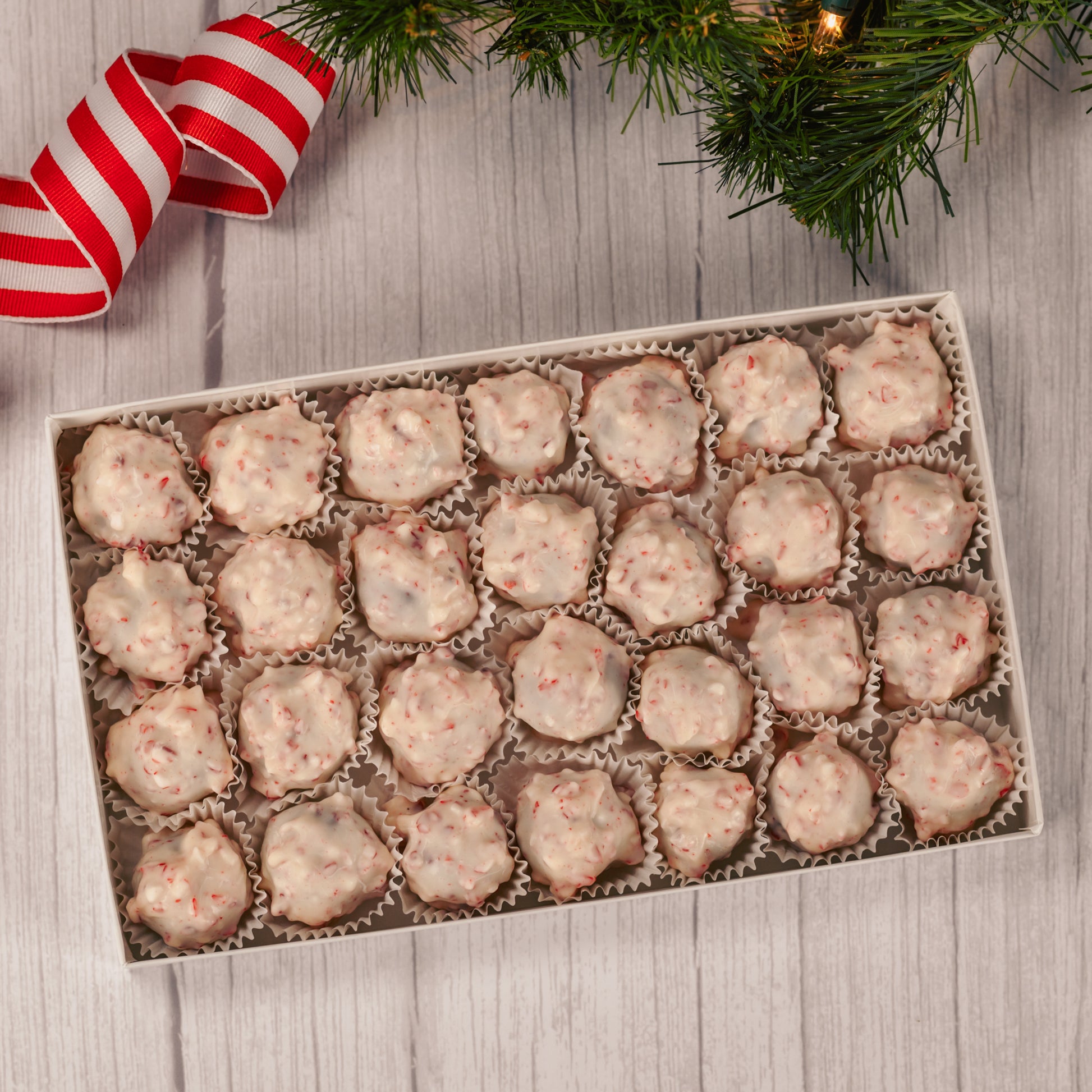 a pound of chocolate cream center covered in white coating with peppermint crunch pieces