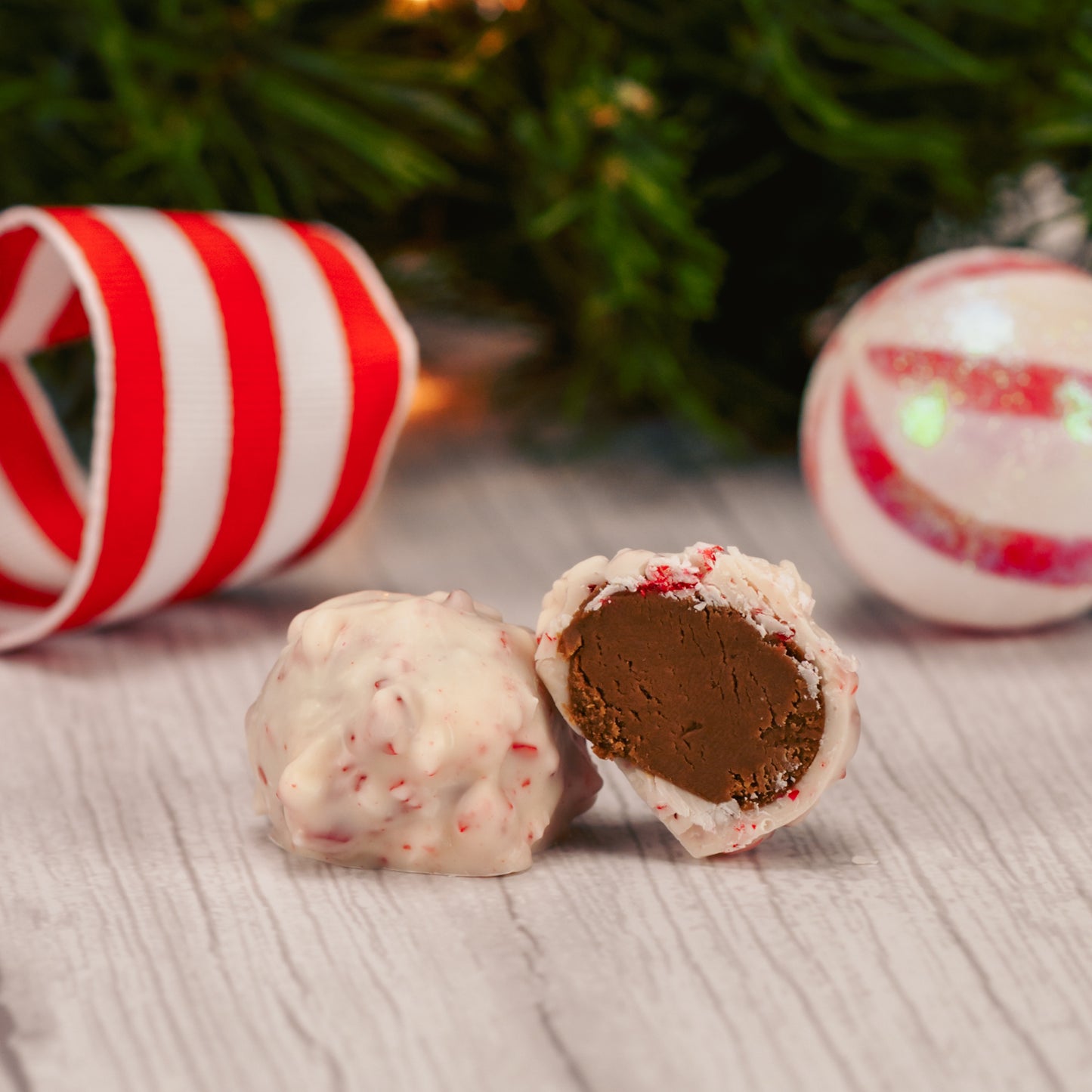 a pound of chocolate cream center covered in white coating with peppermint crunch pieces