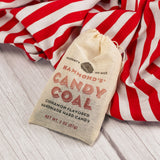 a small bag of candy coal - flavored cinnamon hard candy to look like coal.