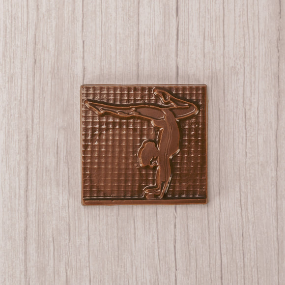 A square plaque of a gymnast in smooth milk chocolate.